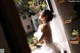 A woman in a wedding dress looking out a window.