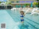 A woman in a blue bikini standing in a swimming pool.