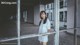 A woman in a white dress standing in an abandoned building.