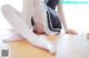 A woman in a maid outfit is sitting on the floor.