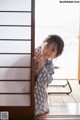 A woman leaning against a sliding door in a room.