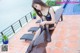 A woman sitting on a bench next to a swimming pool.