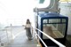 A woman is walking up the stairs of a cable car.