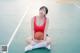 A woman sitting on a basketball court holding a basketball.